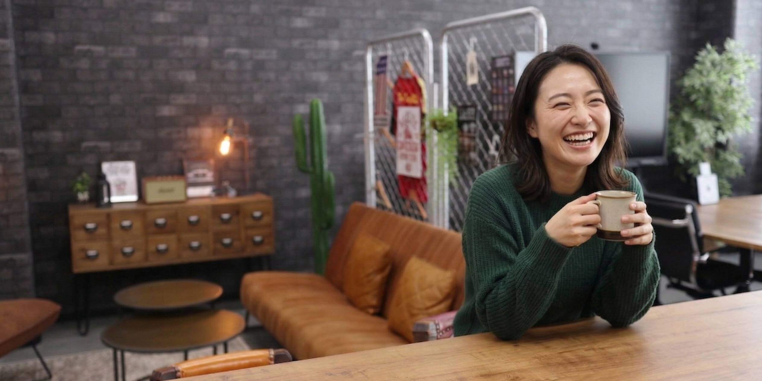 C+Loungeのカフェカフェカウンターに座る笑顔の女性