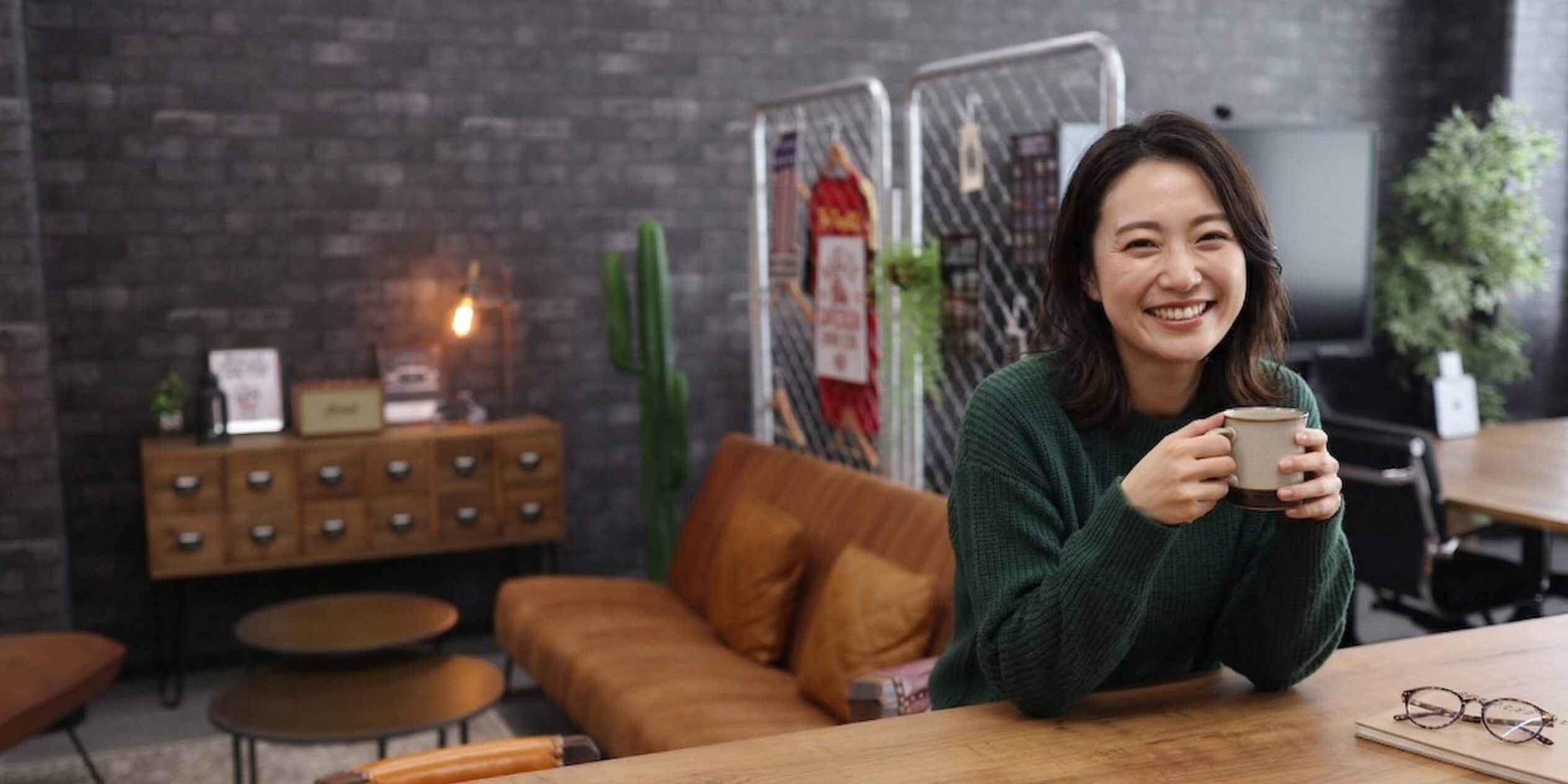 C+Loungeのカフェカフェカウンターに座る笑顔の女性